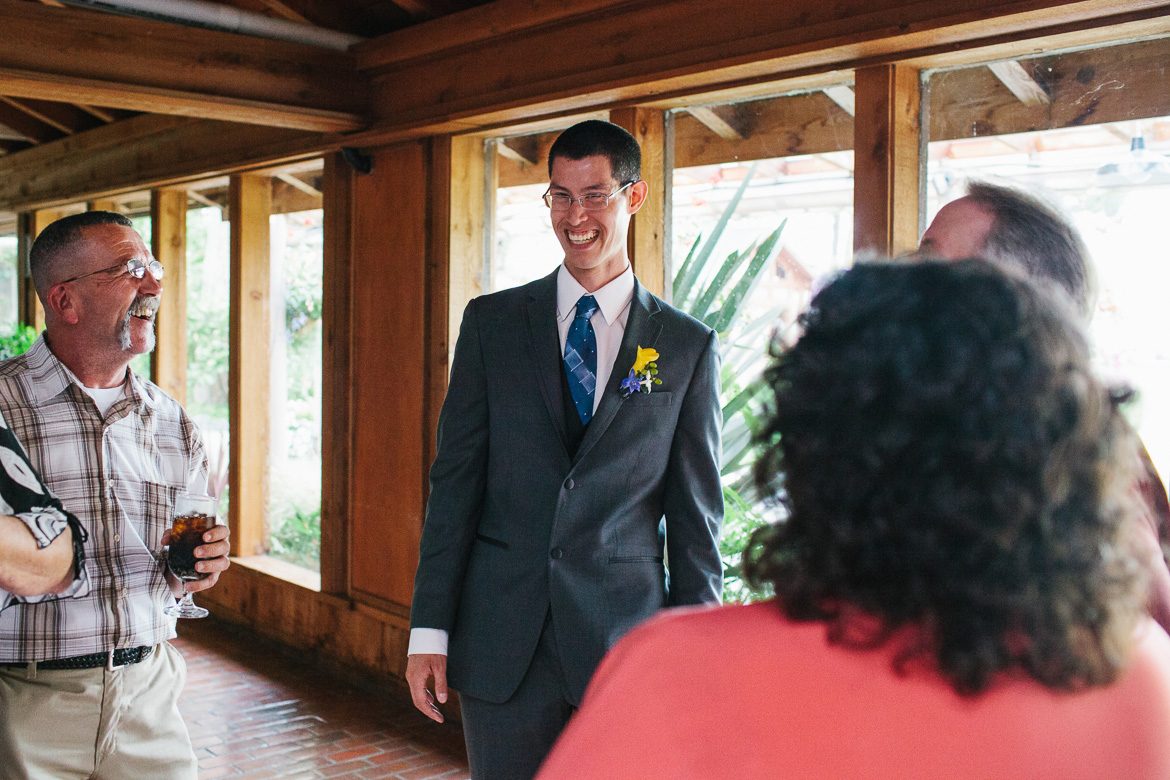 Groom laughing during cocktail hour at Kiana Lodge wedding in Poulsbo, WA