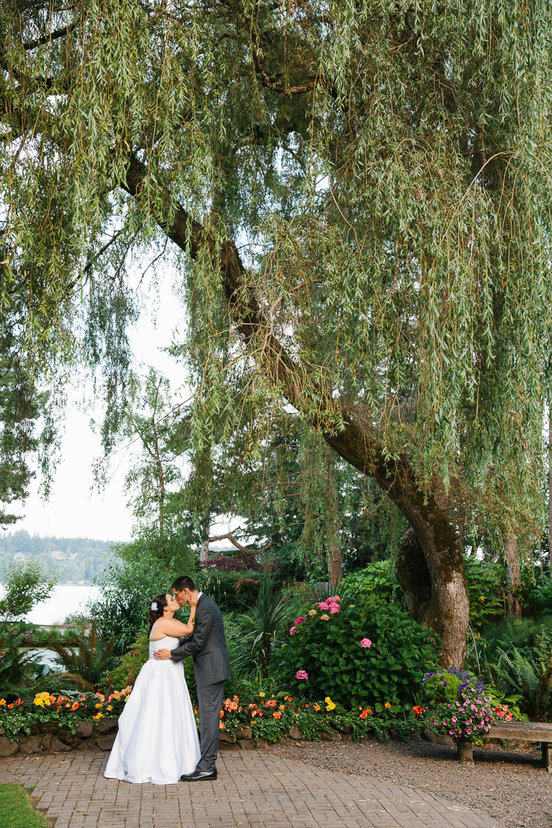 Bride and groom kissing during sunset portrait at Kiana Lodge wedding in Poulsbo, WA