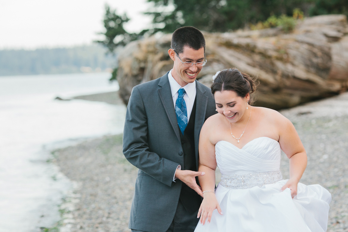 Bride and groom laughing during sunset portrait on beach at Kiana Lodge wedding in Poulsbo, WA