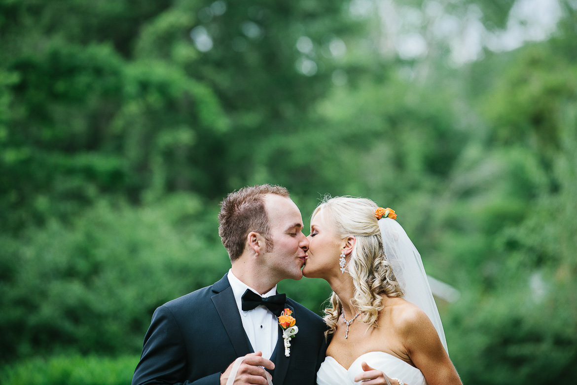 Bride and groom kissing during portrait session at Laurel Creek Manor summer wedding in Sumner, WA