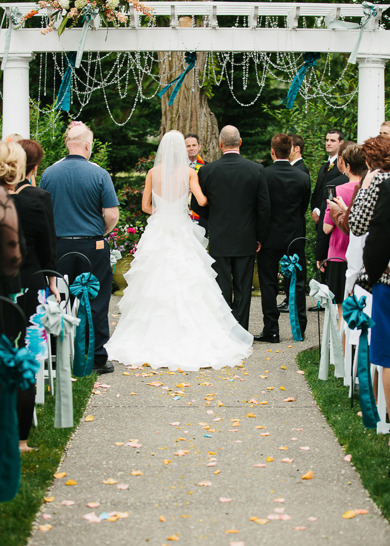 Bride walking down aisle during ceremony at Laurel Creek Manor summer wedding in Sumner, WA