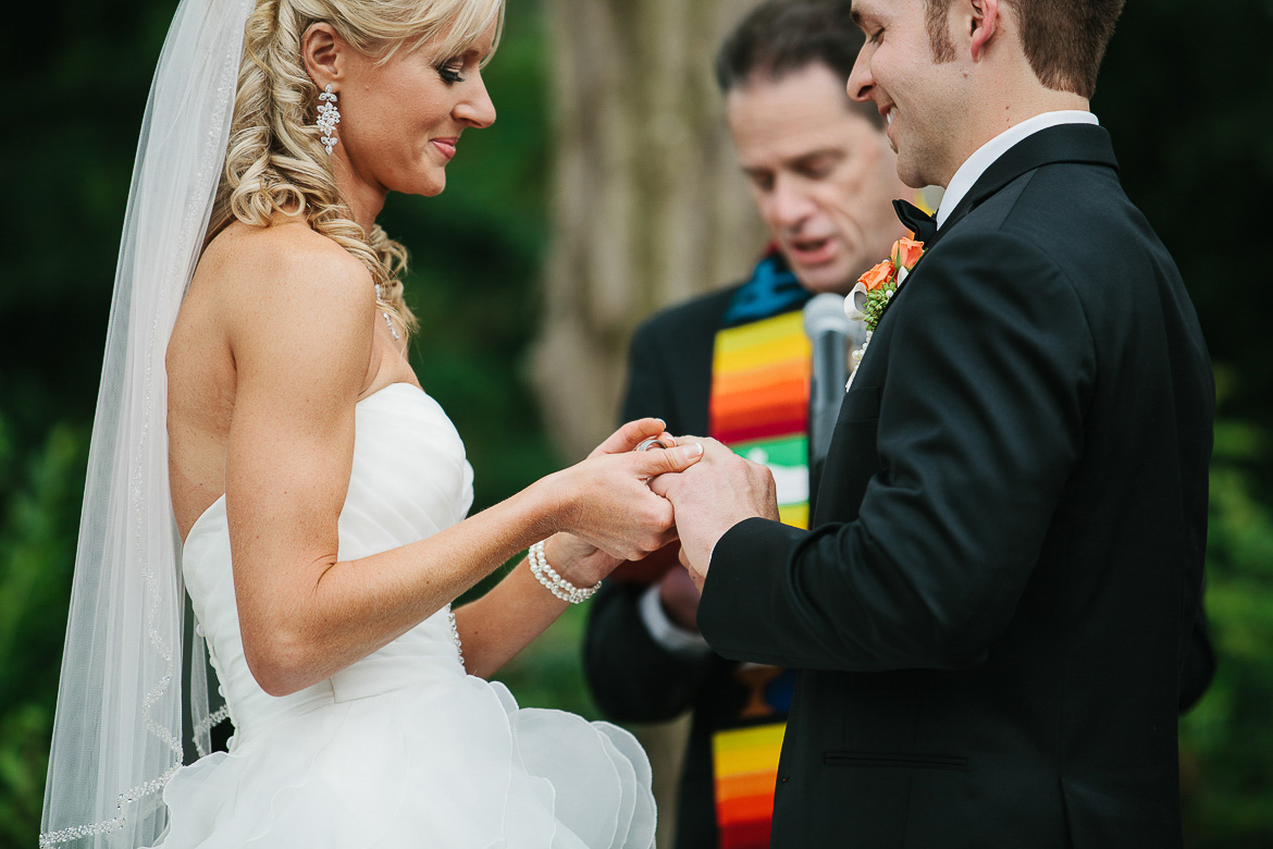 Bride and groom exchanging rings ceremony at Laurel Creek Manor summer wedding in Sumner, WA