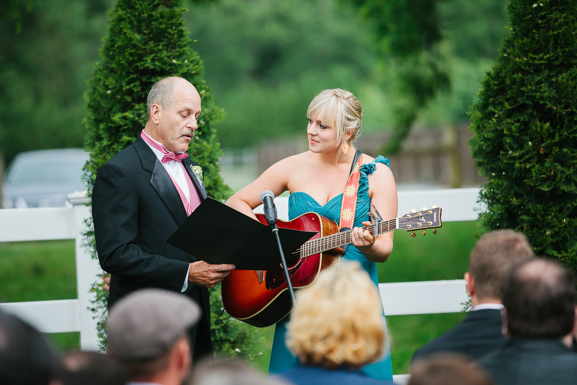 Father of bride and bridesmaid singing during ceremony at Laurel Creek Manor summer wedding in Sumner, WA