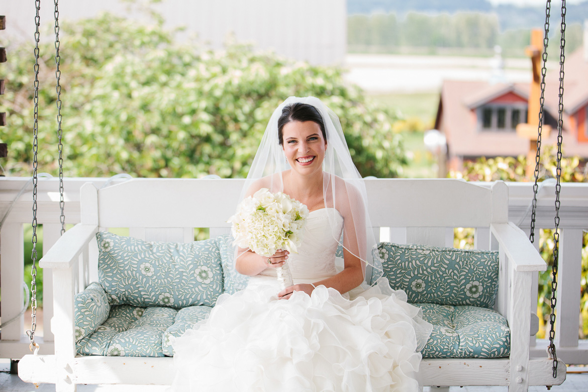 Bride sitting on porch swing before wedding at Lord Hill Farms in Snohomish WA