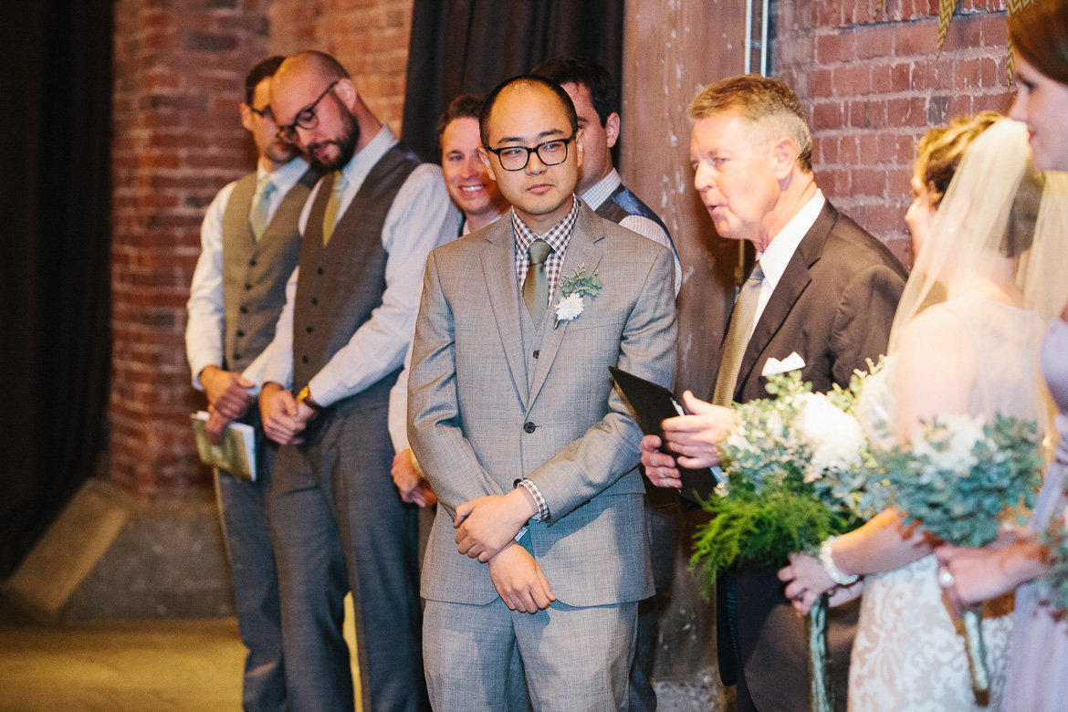 Groom during wedding ceremony at Melrose Market Studios in Seattle, WA