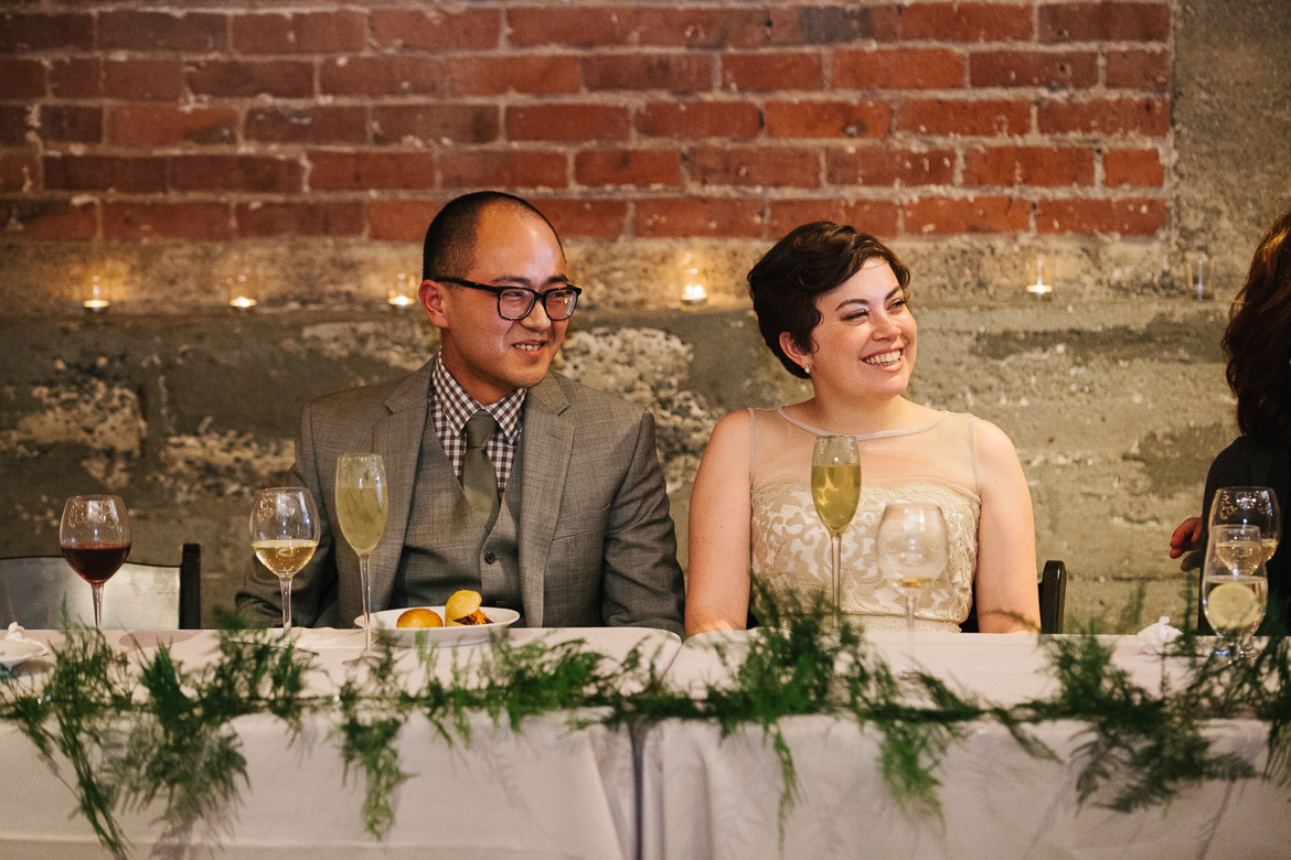 Bride and groom during toasts at their Melrose Market Studios wedding reception in Seattle during photography timeline