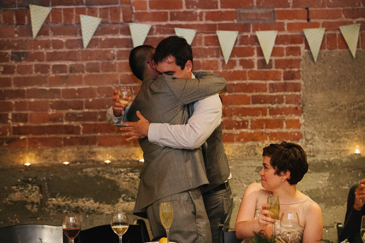 Groom and groomsmen during reception toasts at Melrose Market Studios wedding in Seattle, WA