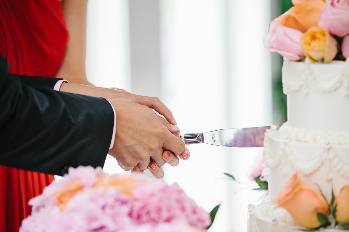 Bride and groom cutting cake during wedding reception at Newcastle Golf Course in Washington