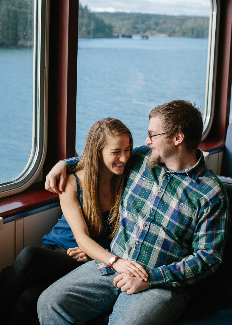 Couple laughing on WA ferry to Orcas Island for engagement session 
