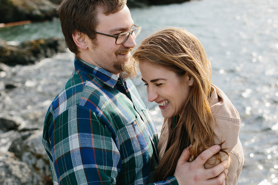Couple laughing during engagement session near water in Eastsound, WA