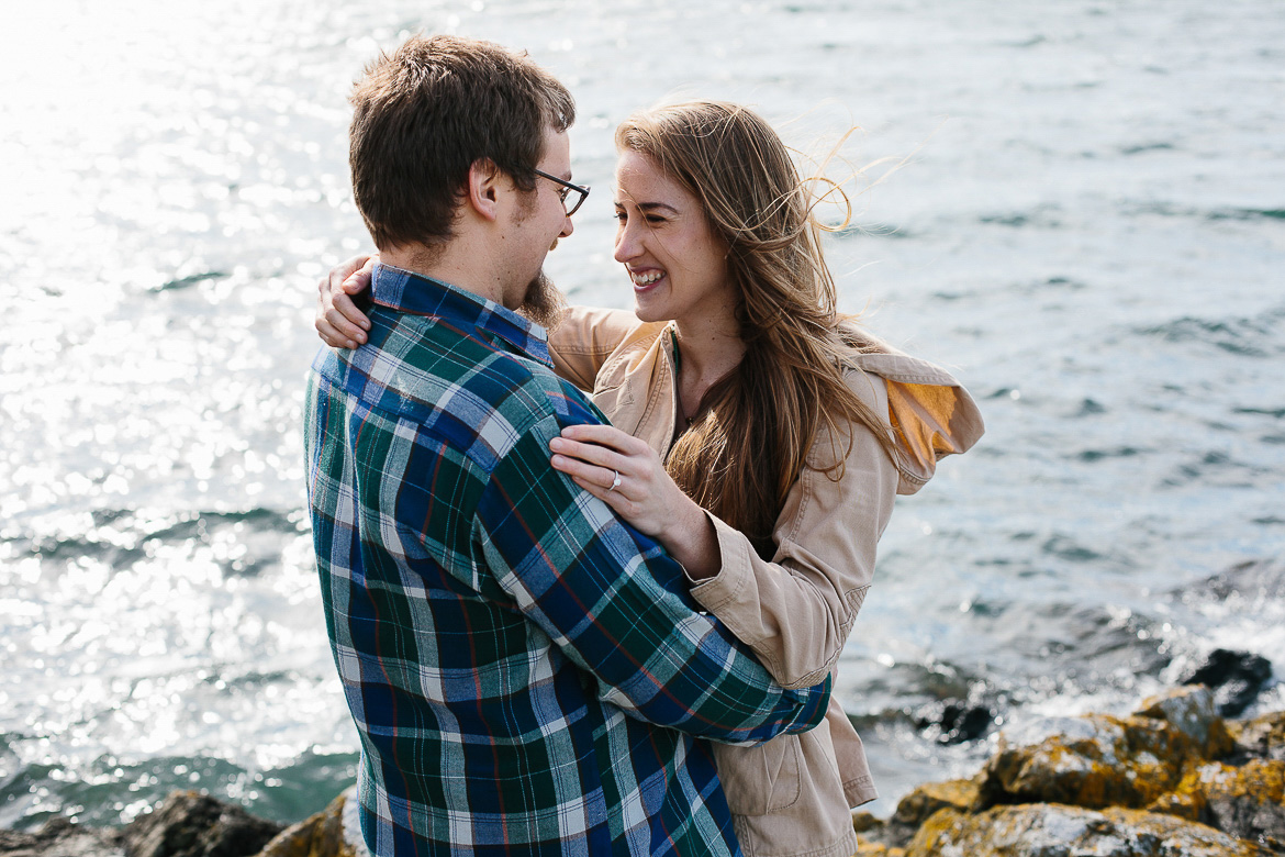 Couple laughing during engagement session near water on Orcas Island, WA