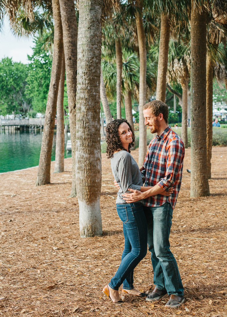 Couple surrounded by palm trees during engagement photo session at Lake Eola Park in Orlando, FL