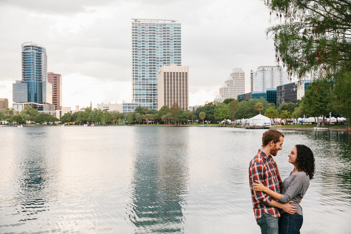 Couple with Orlando skyline in background at Lake Eola Park