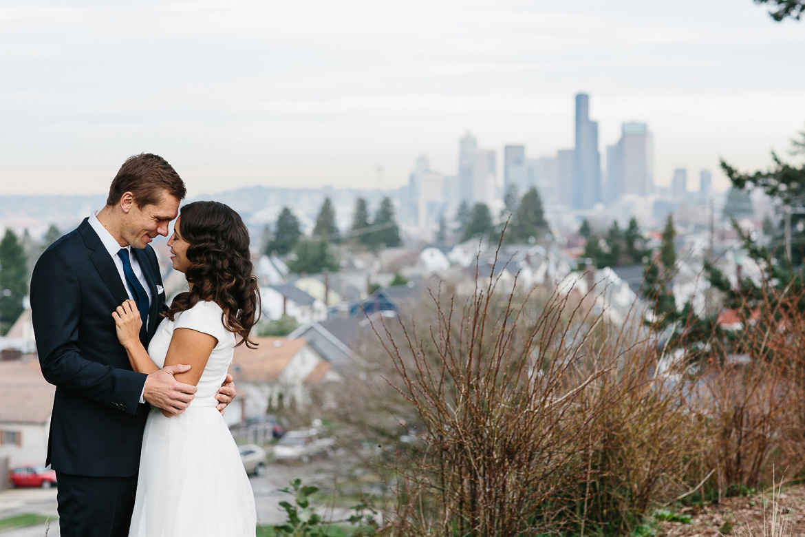 Bride and Groom kissing with Seattle skyline at Jefferson Park on Beacon Hill 