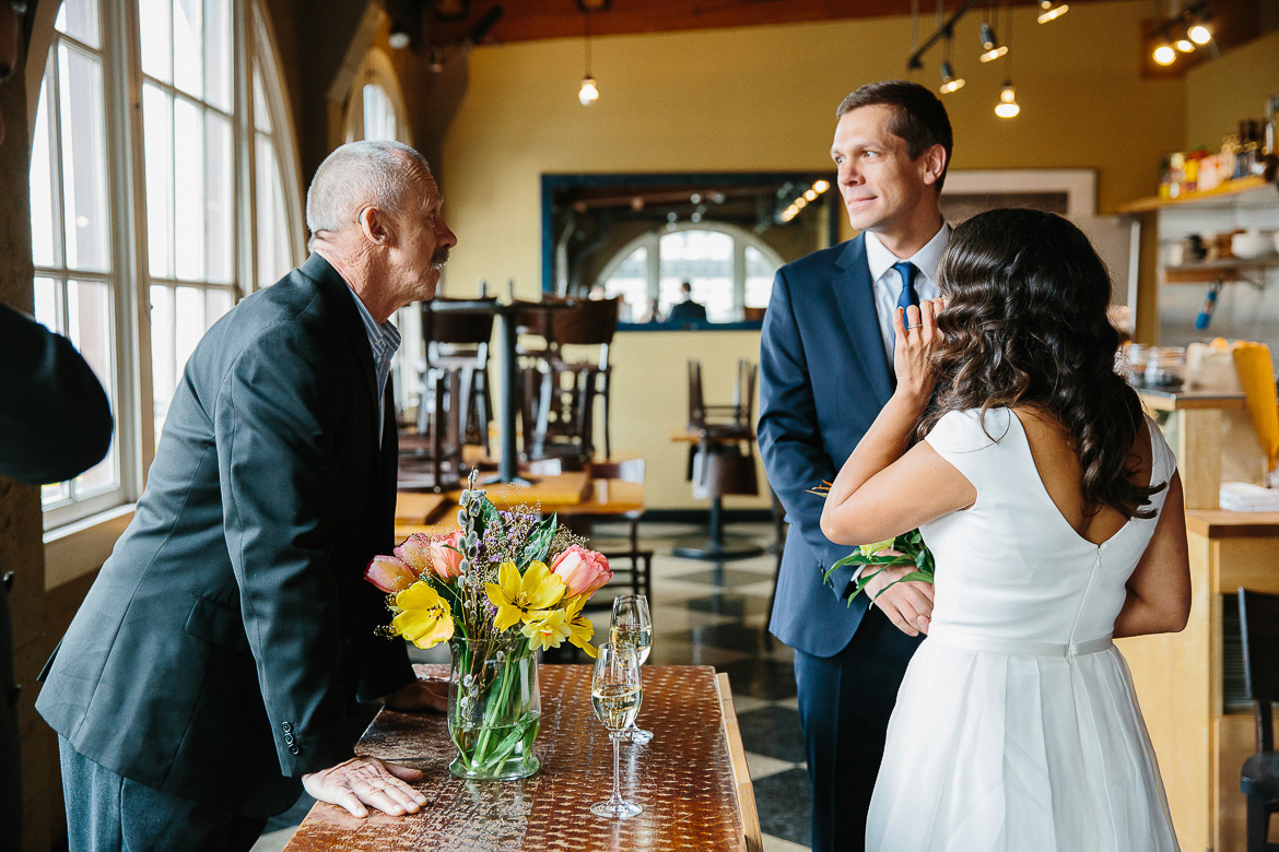 Father of the groom giving prayer during Pike Place Market elopement ceremony