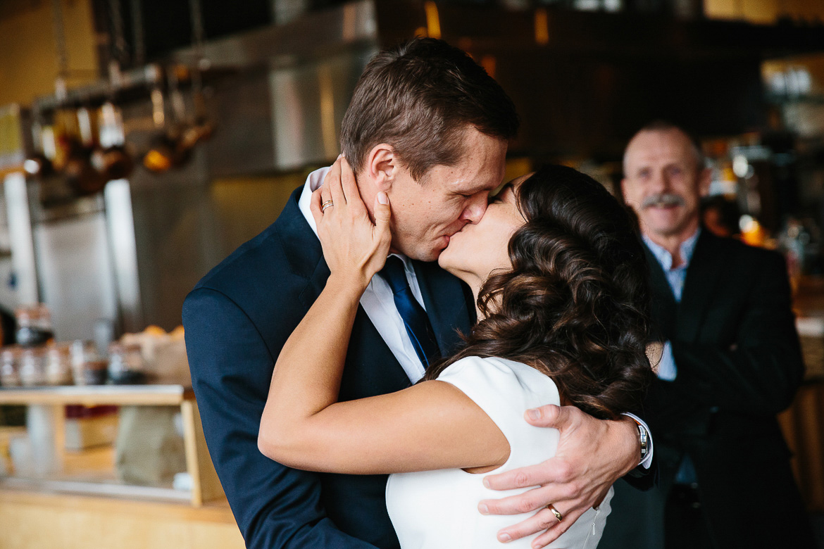 Bride and groom's first kiss during elopement ceremony in Pike Place Market 