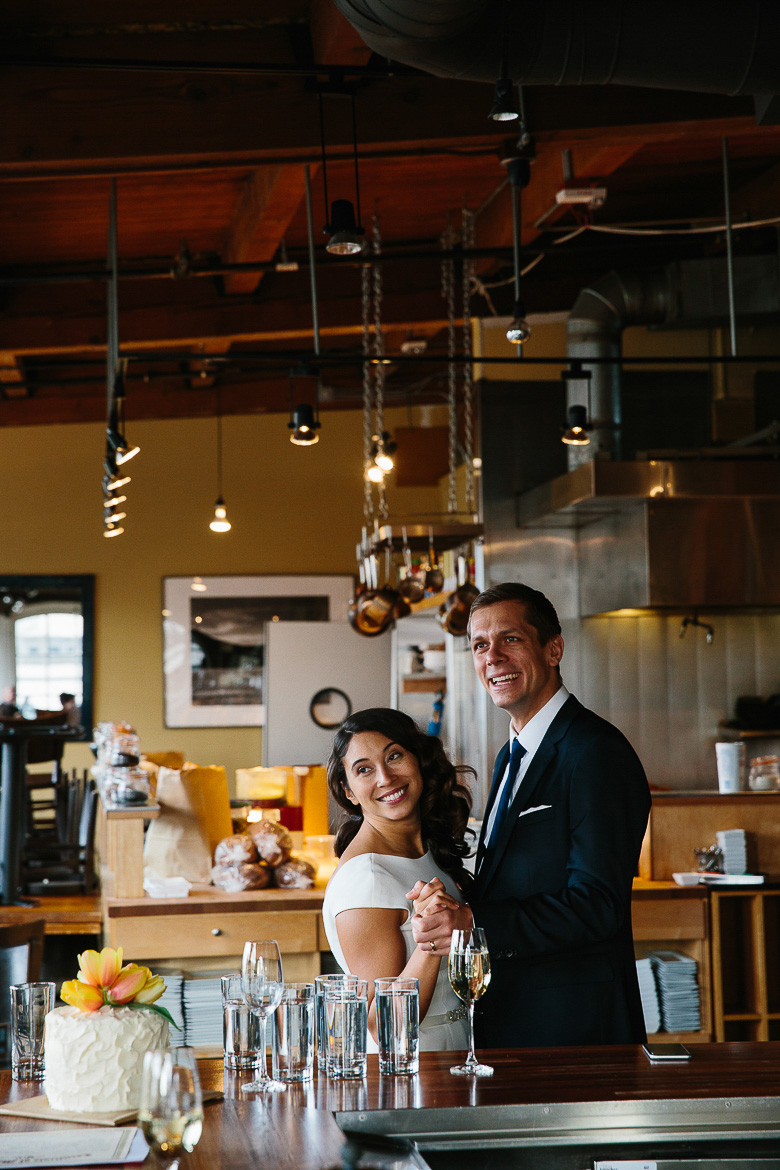Bride and groom laughing post elopement ceremony at Pike Place Market in Seattle, WA