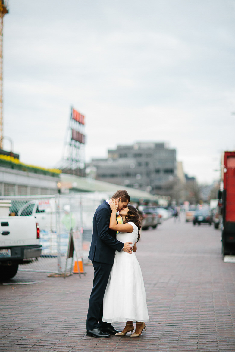 Bride and groom kissing during photo session at Pike Place Market in Seattle, WA