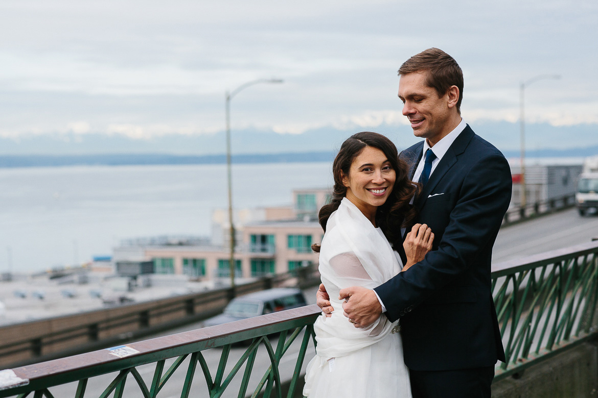 Bride and groom with Olympic Mountians behind them on the Seattle waterfront