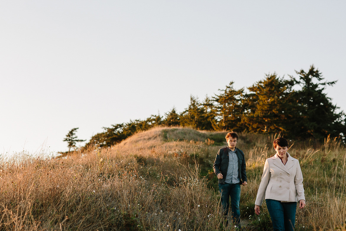 Couple walking down bluffs during engagement session at Ebey's Landing on Whidbey Island