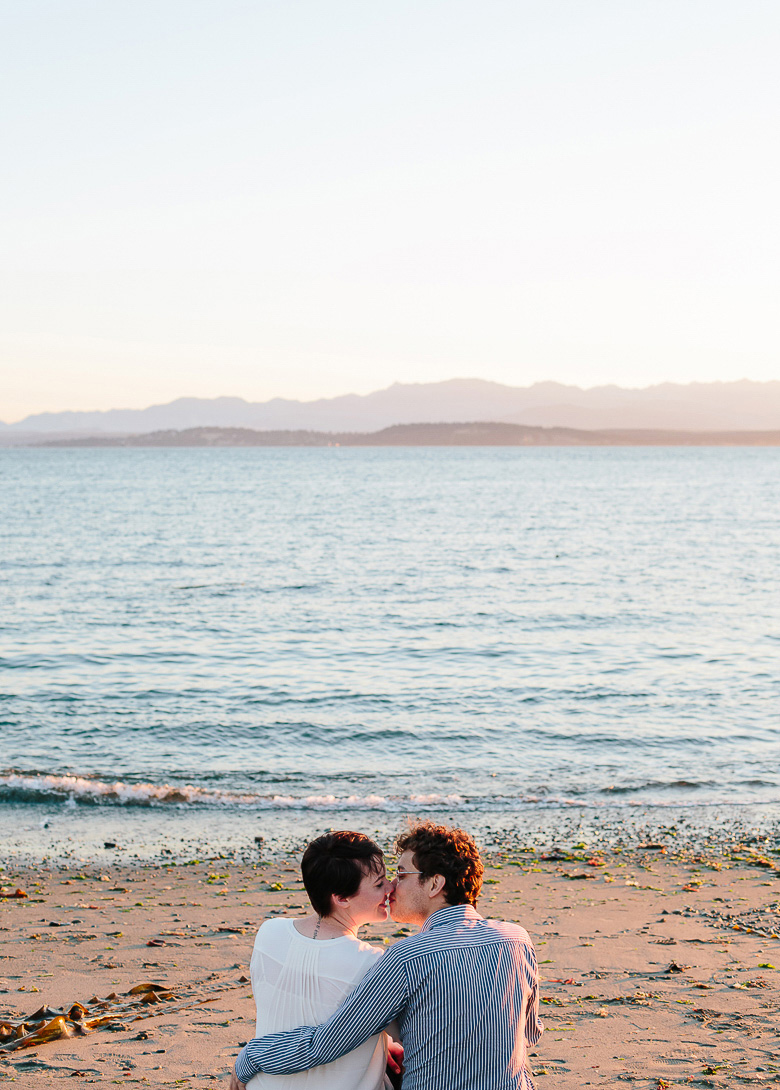 Couple kissing on Whidbey Island beach during engagement session at Ebey's Landing