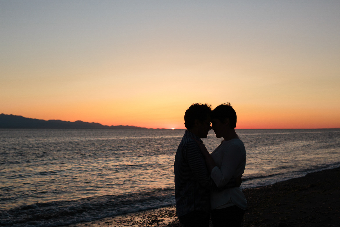 Couple walking on beach during sunset for engagement photos at Ebey's Landing
